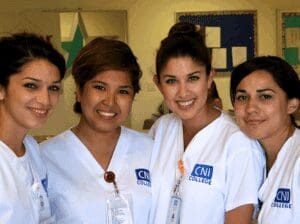 Four nursing students standing together in a hallway