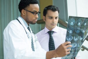 A doctor and technician examining an MRI scan