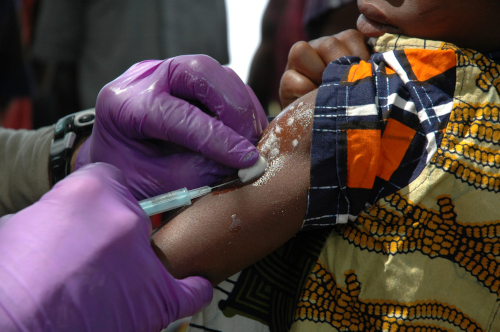 A nurse giving a child a vaccine in rural Africa