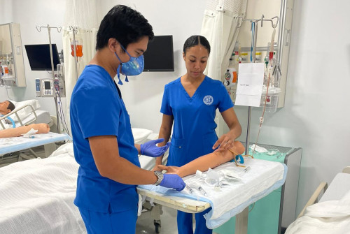 Two CNI College nursing students practicing taking blood