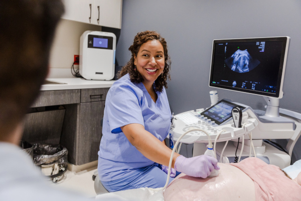 A diagnostic sonographer scanning a pregnant woman