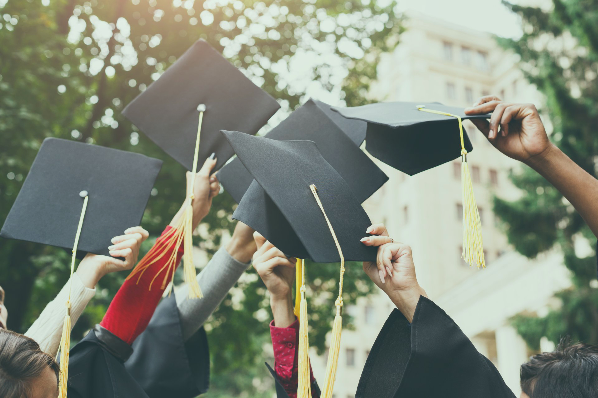Students holding graduation caps
