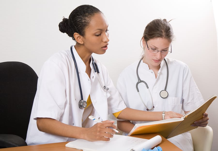 Two nurses looking over a file
